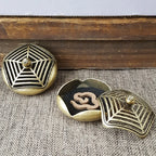 Brass pocket incense burner set with lattice-pattern lid and black insert showing swirl motif