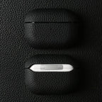 Obsidian black leather AirPods case, closed and bottom edge shows small indicator cutout