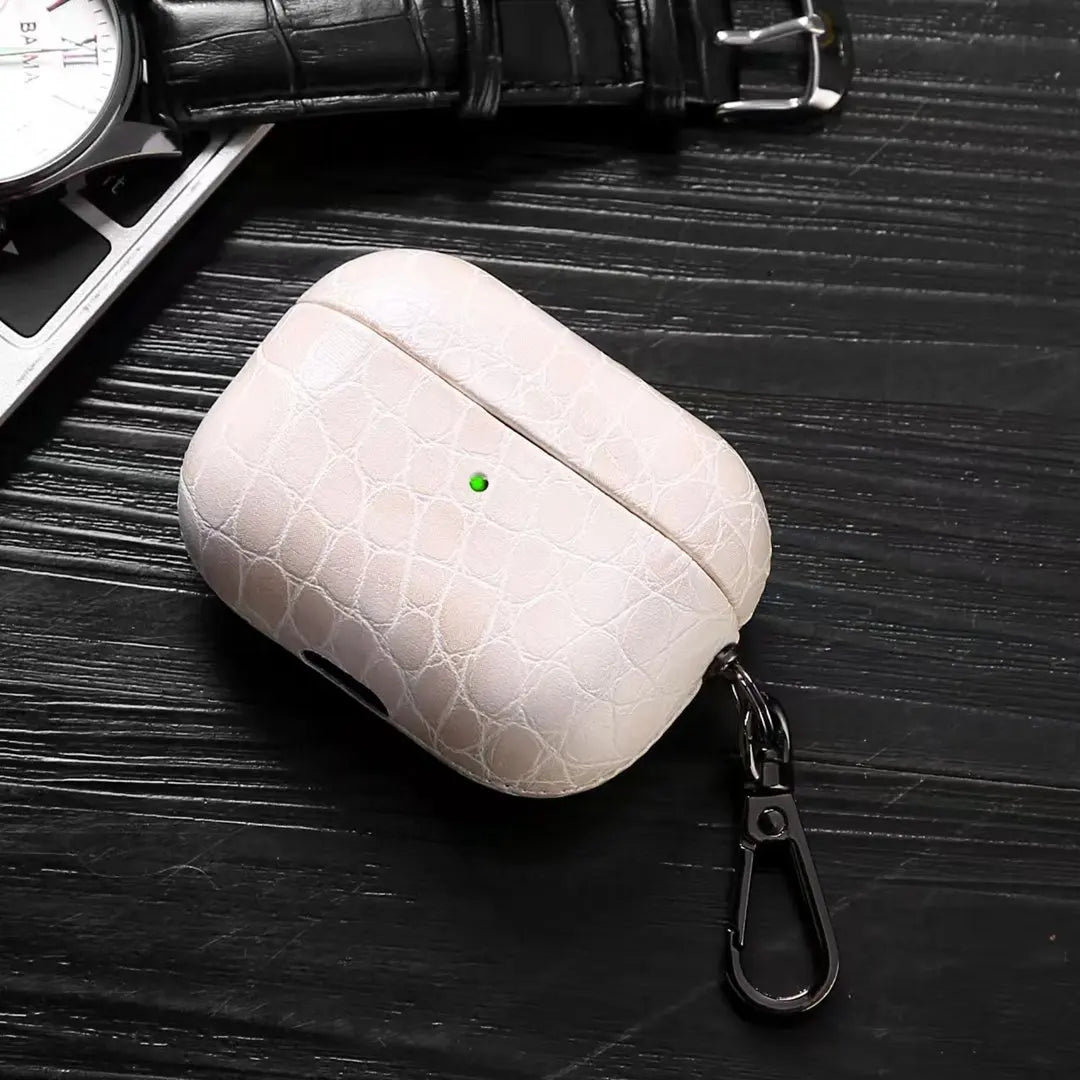 Pearl white crocodile-grain AirPods case with keychain carabiner clip.