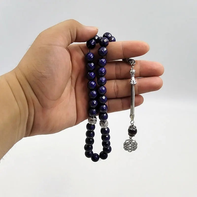 Tasbih misbaha in hand with deep purple 10mm beads, silver-toned end caps, and chain tassel