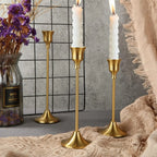 Gold metal candle holder set with three tall stands and fluted bases