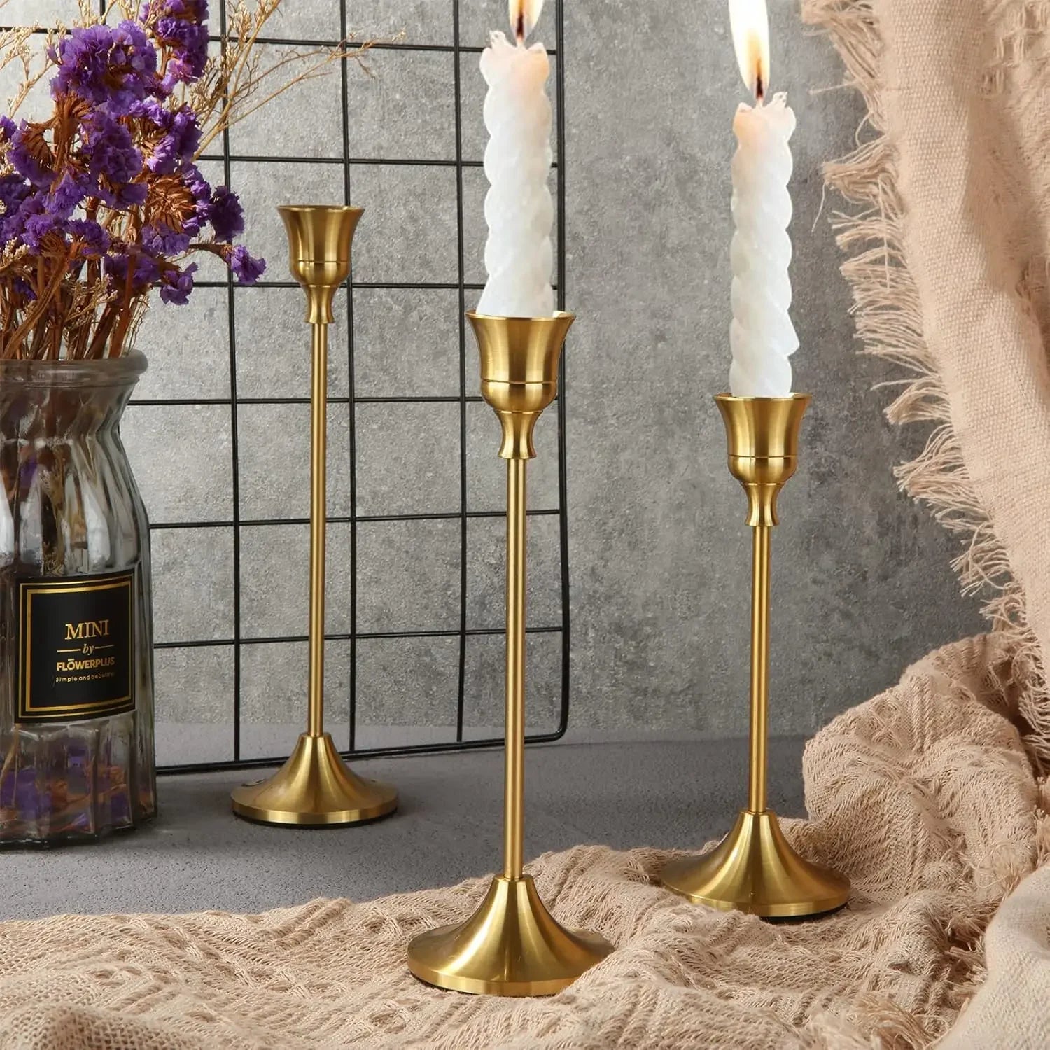Gold metal candle holder set with three tall stands and fluted bases