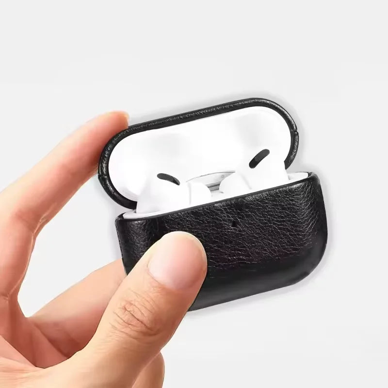 Metal keychain AirPods case in black leather held open by a hand