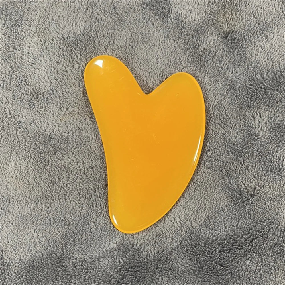 Honey amber gua sha stone with glossy golden-yellow, curved teardrop shape.