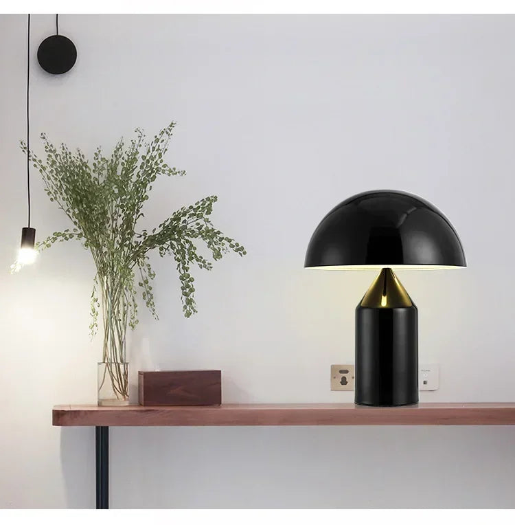 Black mushroom table lamp with gold interior dome shade and cylindrical glass base