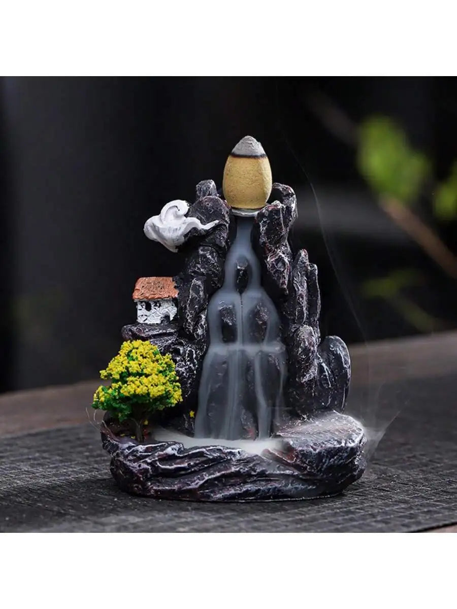 Backflow waterfall incense holder with yellow flowers, small house, and central smoke cascade
