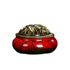 Ceramic incense burner with red speckled glaze and ornate gold lid