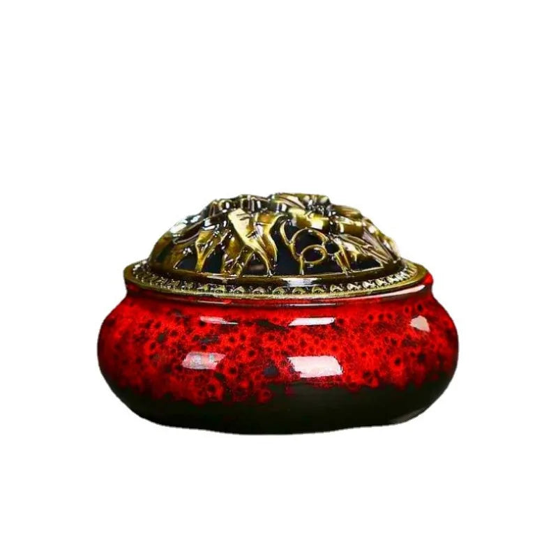 Ceramic incense burner with red speckled glaze and ornate gold lid