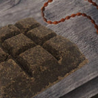 Dark brown bakhoor incense bricks arranged on a textured surface