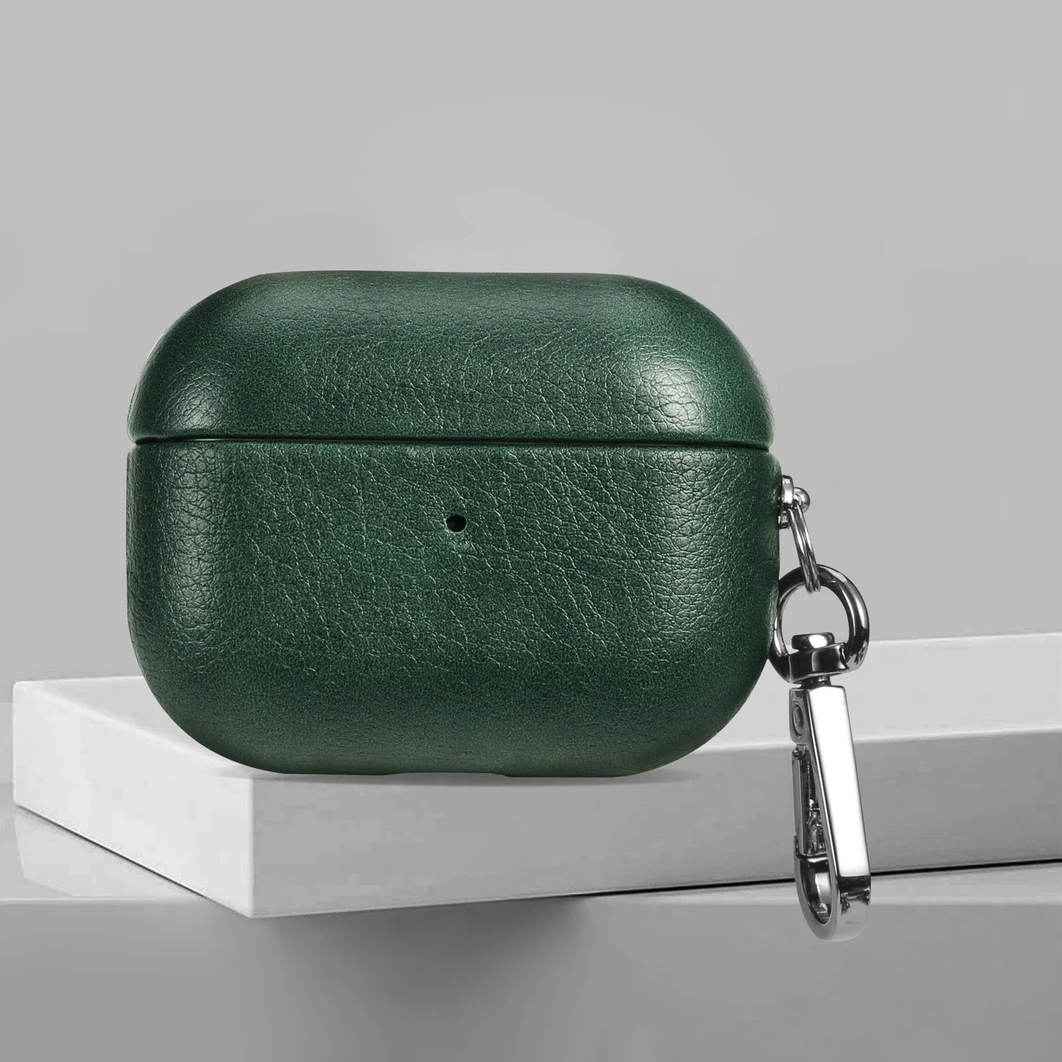 Forest green leather AirPods case with metal keychain clip and charging-LED dot