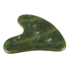 Heart-shaped jade gua sha massager, green polished Xiuyan jade close-up
