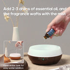 Dark wood aroma diffuser with essential oil bottle dropper near the top