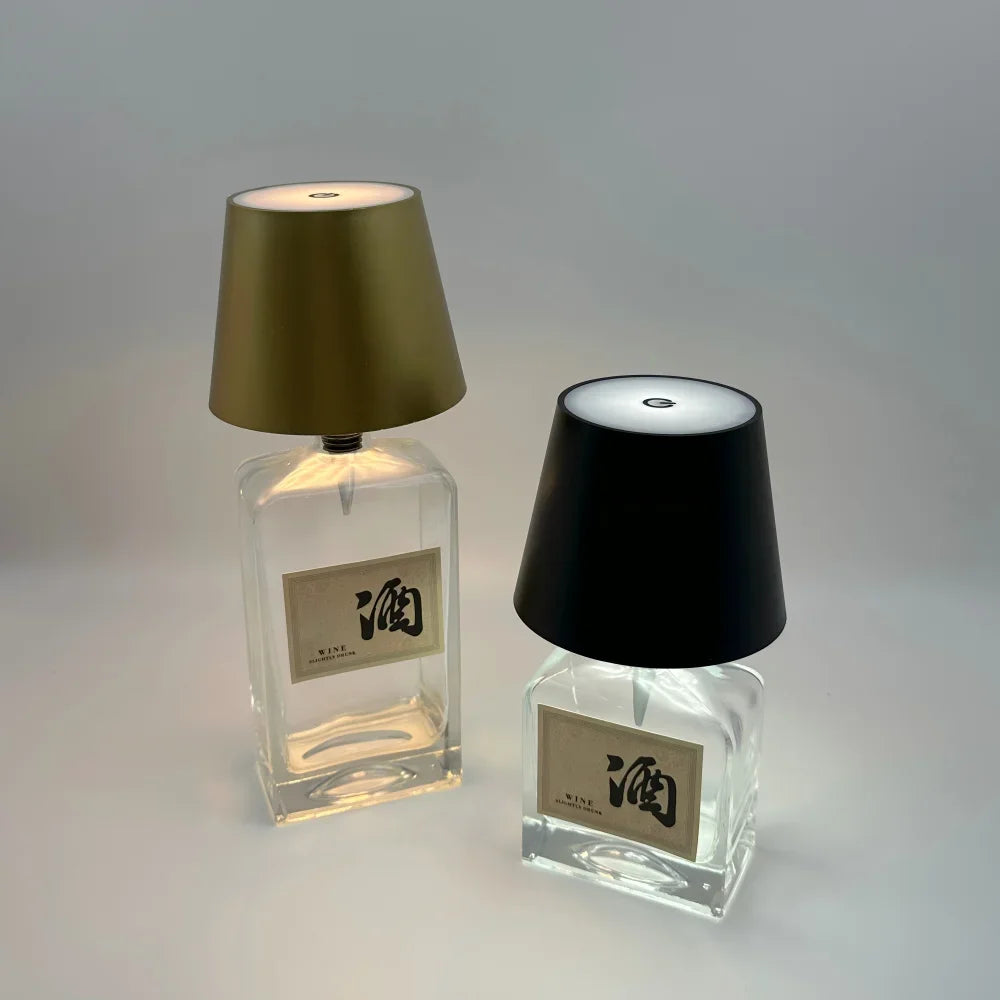 Clear wine-bottle LED lamps with gold and black lampshades, each glowing