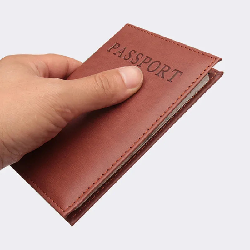 Reddish-brown passport sleeve held closed with embossed “PASSPORT” lettering