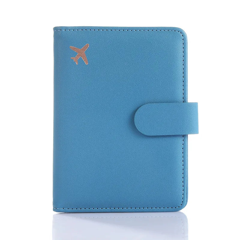 Blue passport folio with embossed airplane icon, snap strap closure, and stitched borders