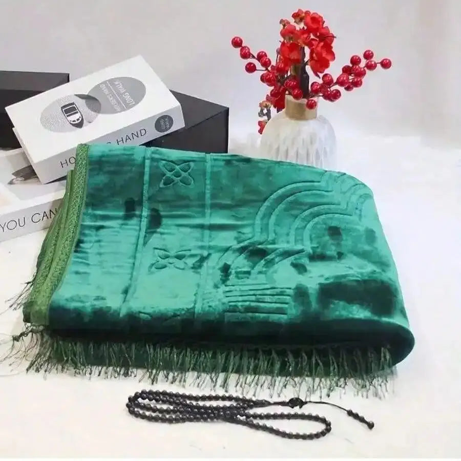 Velvet padded prayer rug in deep green with raised arch design and long fringe trim.