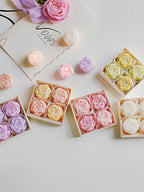 Pastel rose-shaped soy wax candles with multiple small gift boxes