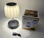 Cordless LED table lamp with white shade, black base, and included charging cable