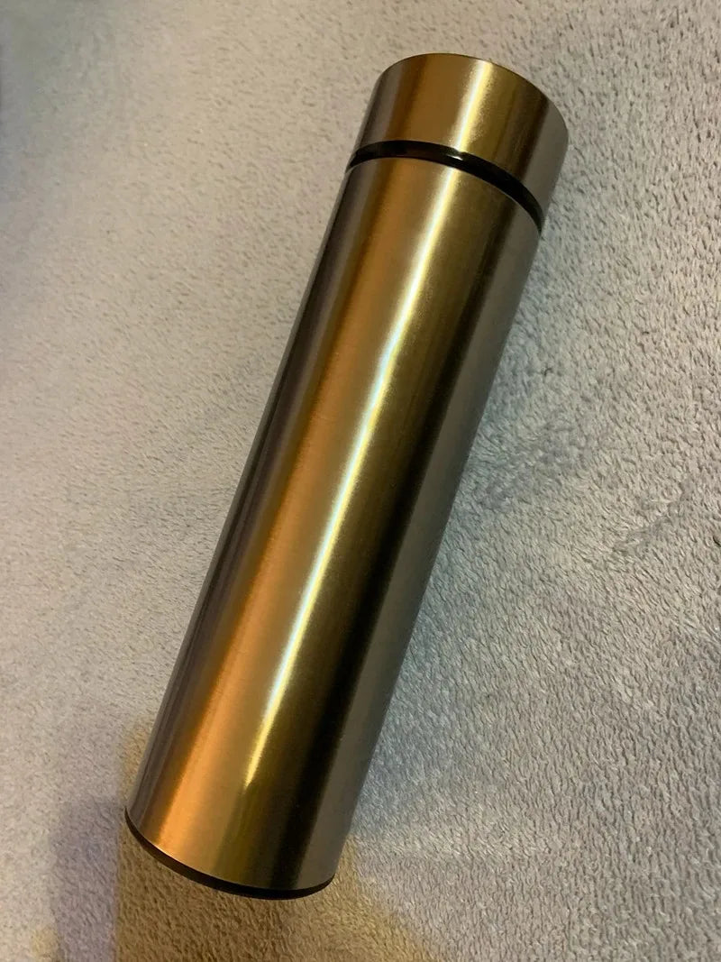 Gold insulated thermos bottle with black top ring