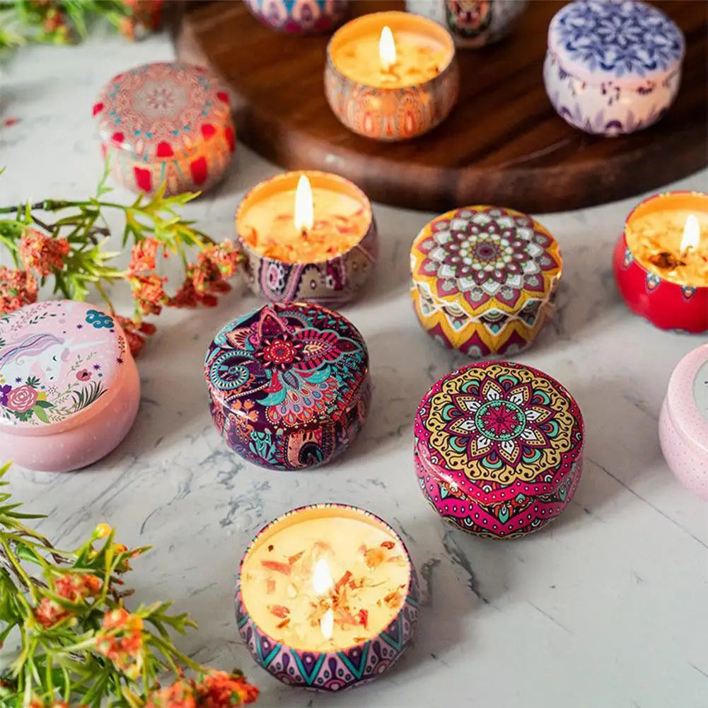 Multiple flame-lit vintage jar scented candles with colorful patterned lids on tabletop
