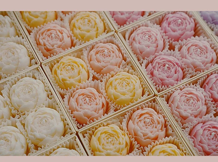 Assorted rose-shaped scented candles in a divided gift tray, close-up