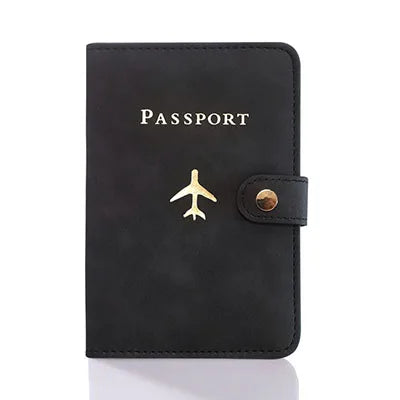 Onyx black passport folio with gold airplane icon, snap strap, and “PASSPORT” text