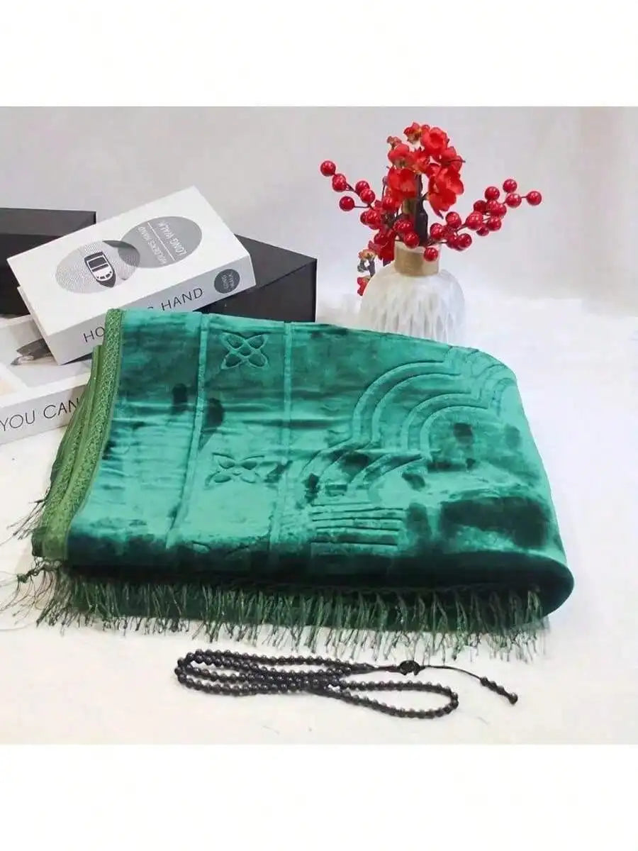 Velvet padded prayer rug in green with raised arch design and long fringe trim along edge.