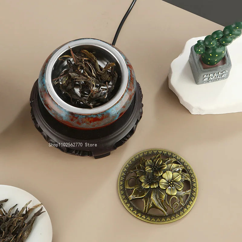 Ceramic electric incense warmer: metal bowl filled with dark incense and connected cable