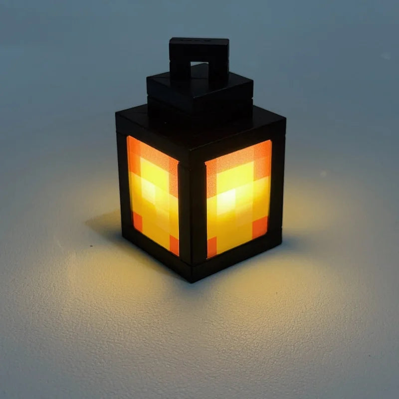 Black lantern night light with pixel pattern glowing orange and yellow through panels