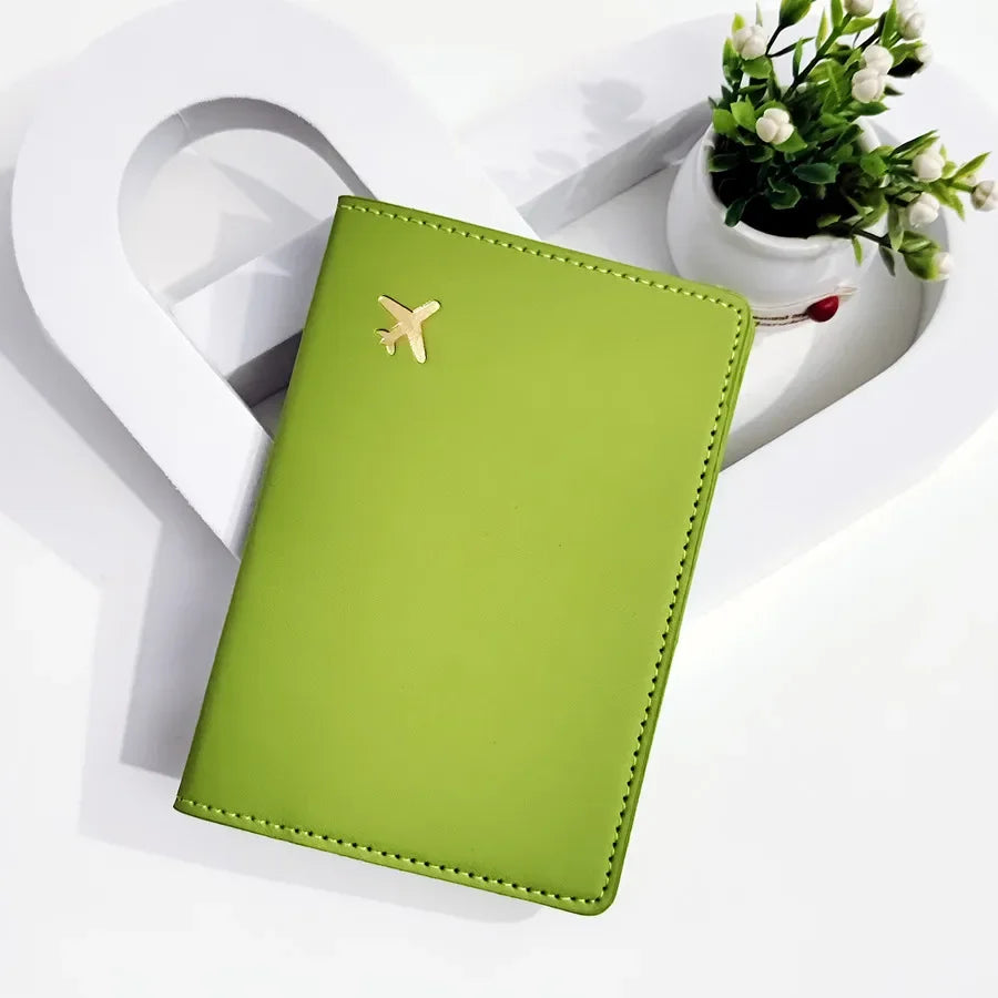 Forest green passport sleeve with gold plane emblem and stitched border