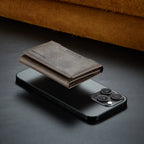 Gray slim leather wallet with card slots, attached to a phone, closed
