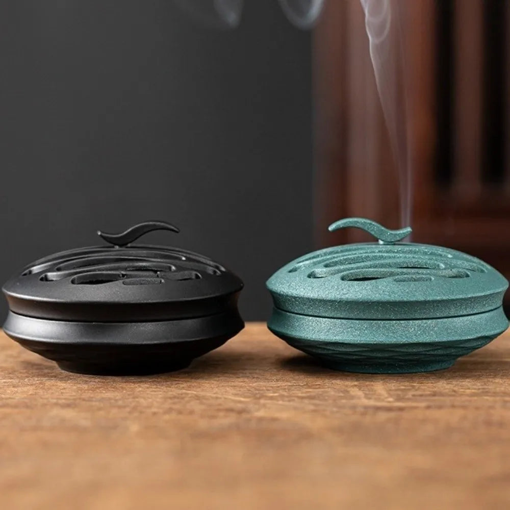 Black and blue incense burners with smoke rising from the vents
