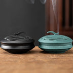 Black and blue incense burners with smoke rising from the vents