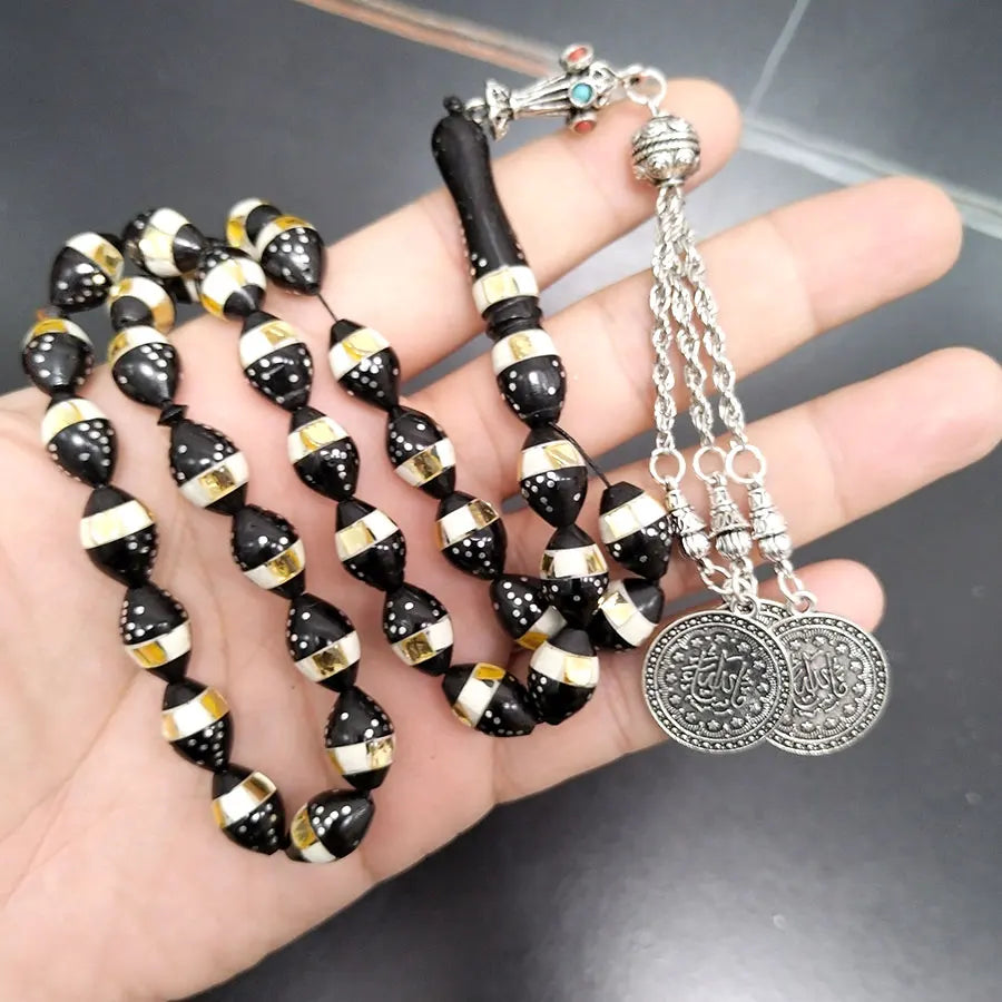 Tasbih prayer beads with black, gold, and dotted beads and silver medallion pendants