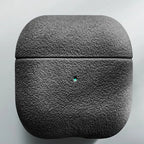 Italian suede AirPods case in Obsidian, closed case with visible charging-light pin