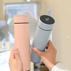 Insulated thermos bottles in peach and light gray with black digital temperature lids