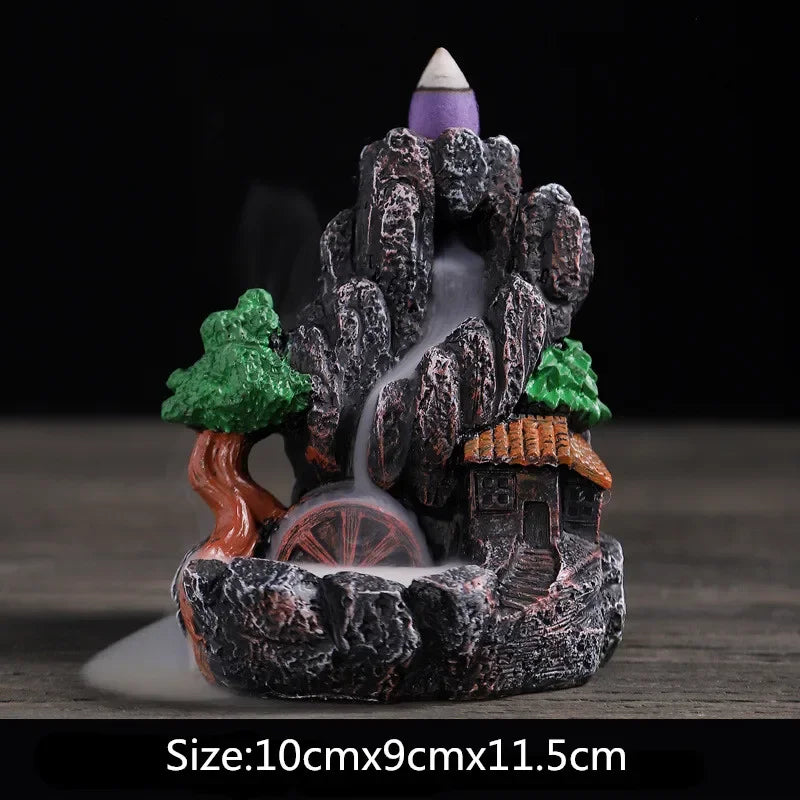 Resin landscape waterfall incense burner with green trees, orange-roof houses, and purple incense cone