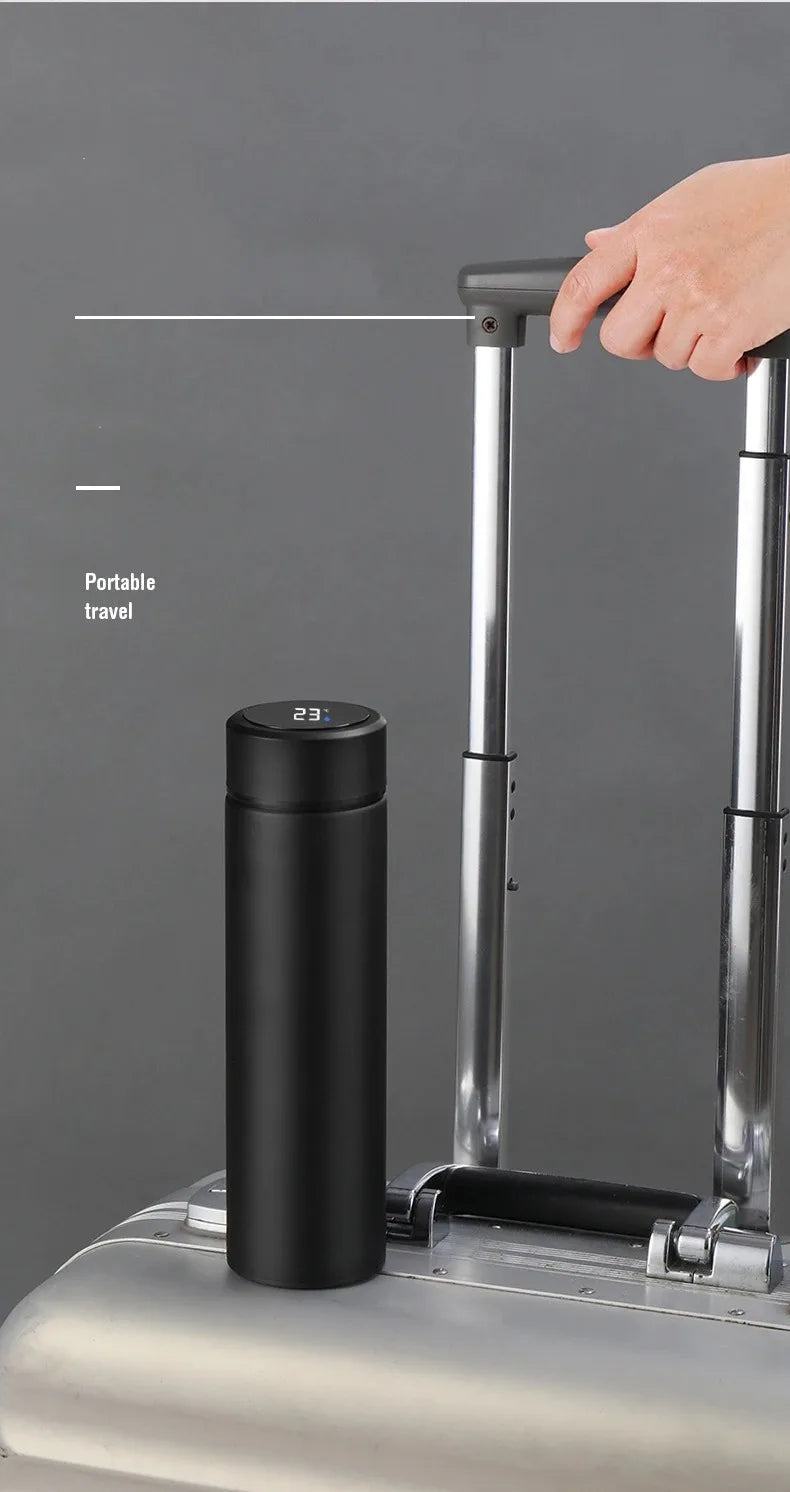 Black insulated thermos bottle next to luggage handle for travel