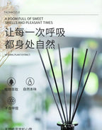 Reed diffuser reeds rising from dark base in a tall holder, with diffuser sticks