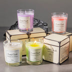 Scented candle gift set with lit purple, orange, and green candles on boxes