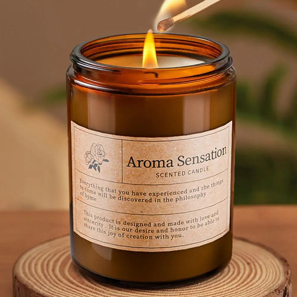 Amber scented candle jar with label and flame, warm wax filling the glass cup
