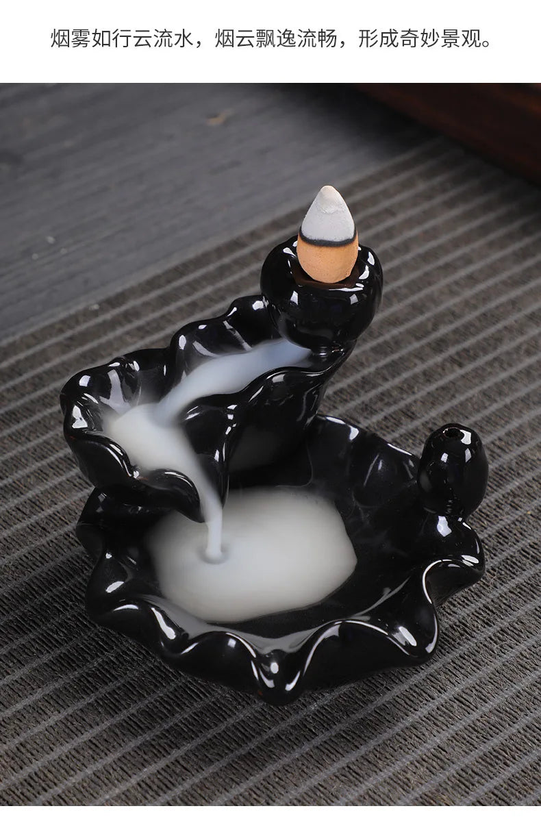 Tower backflow incense burner with incense cone rising from black-and-white glaze