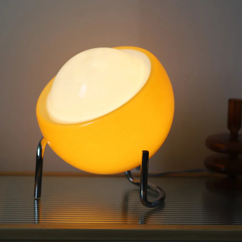 Amber glow glass globe table lamp with chrome ring base and two curved legs