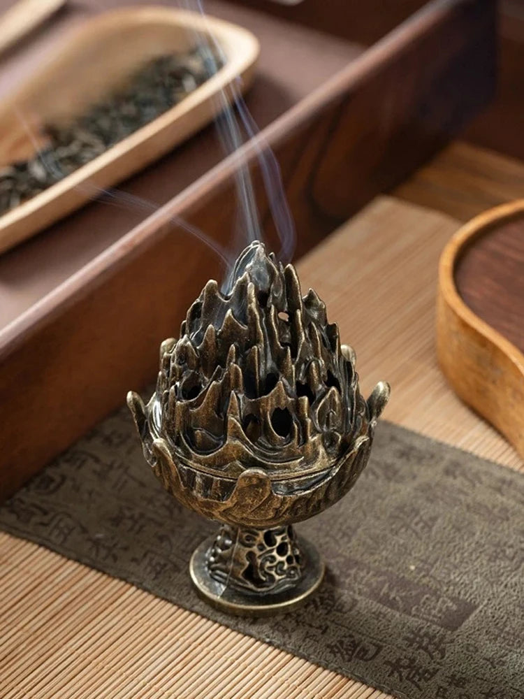 Copper incense censer on textured mat, flame-top bowl with rising smoke