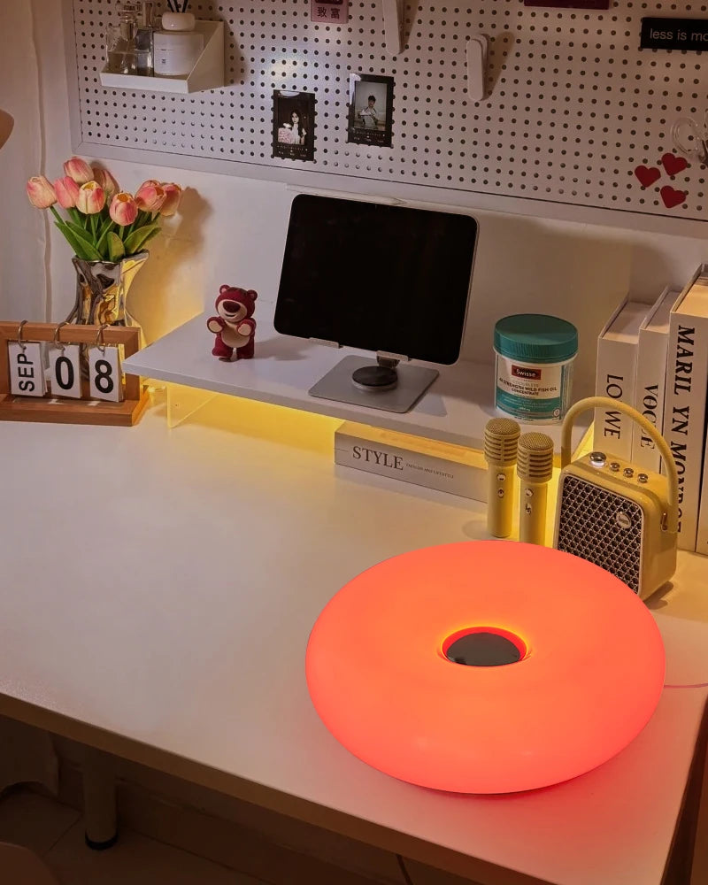 Orange donut table lamp glowing on a counter with round center opening