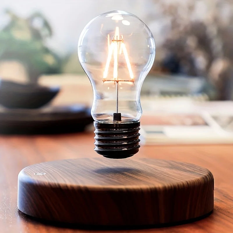 Magnetic LED night lamp with glowing clear bulb on round dark wooden base