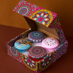 Geöffnetes Geschenkset mit 4 Duftkerzen in Mandala-Design: blau, lila, rot, violett