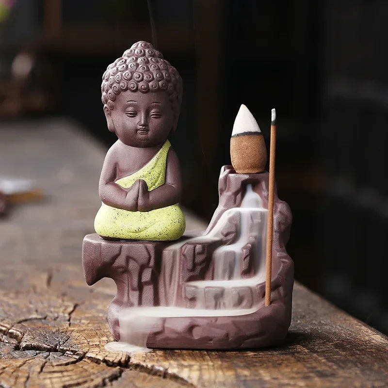 Backflow incense burner, saffron-yellow robed Buddha with incense cone and smoky flow