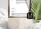 Reed diffuser bottle with reeds beside SGS document frame, 50ml