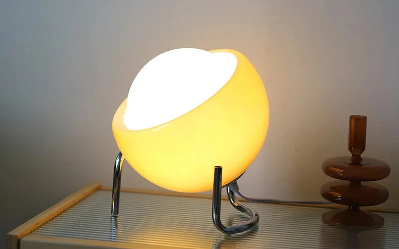 Yellow-orange glass globe table lamp with chrome stand and warm light